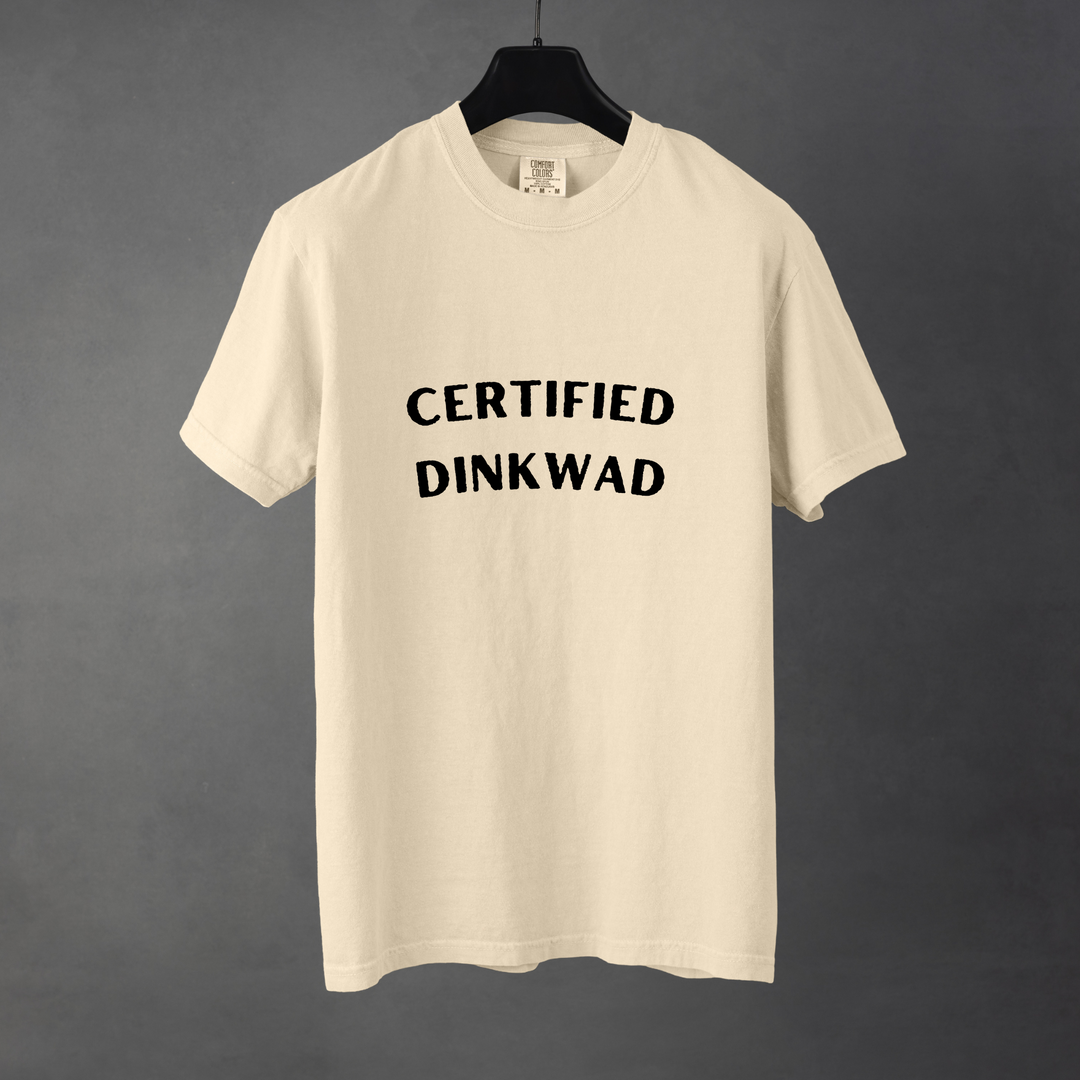 Sarcastic funny ivory graphic t-shirt with bold text saying'Certified Dinkwad'