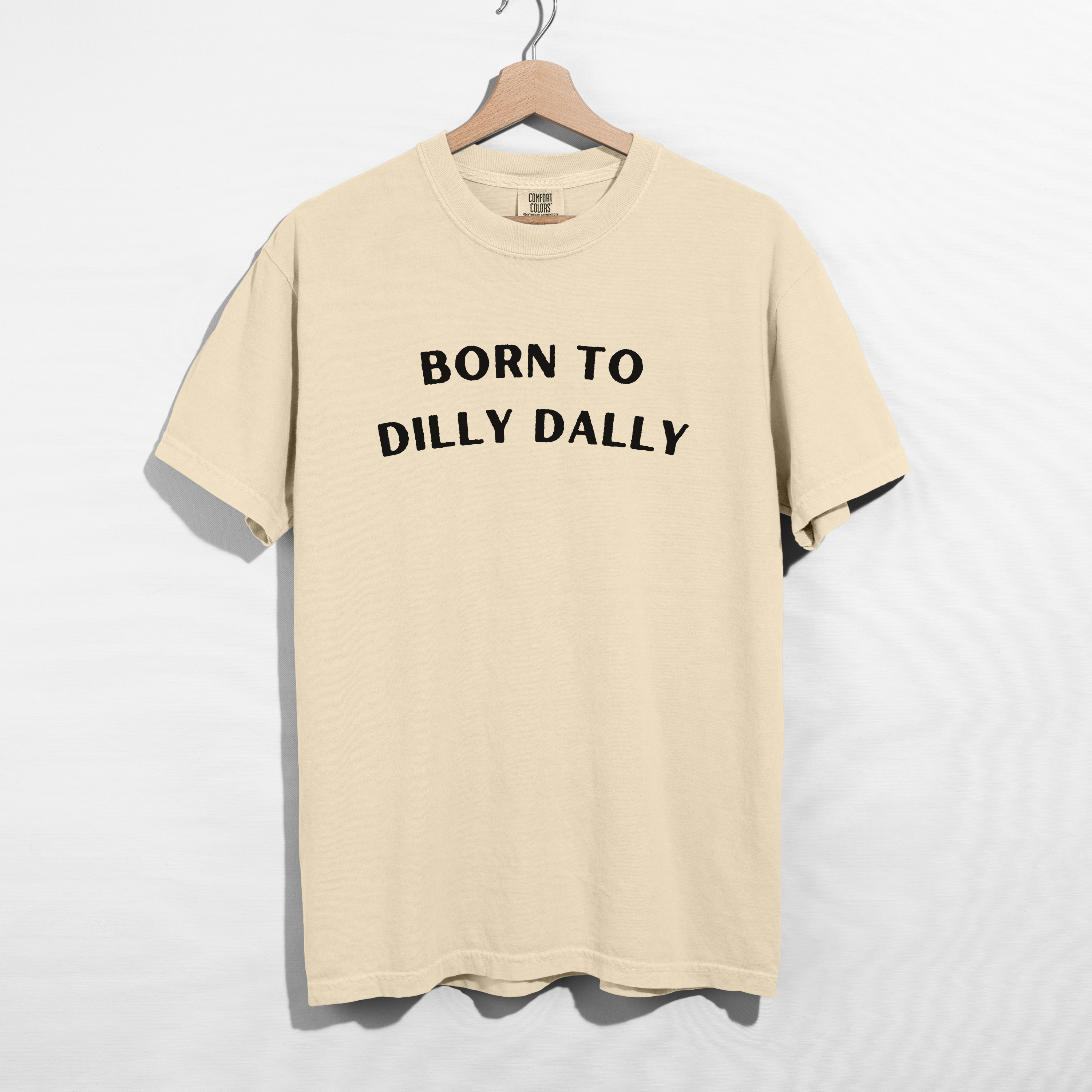 Sarcastic funny cream ivory graphic t-shirt with bold text saying 'Born to Dilly Dally'